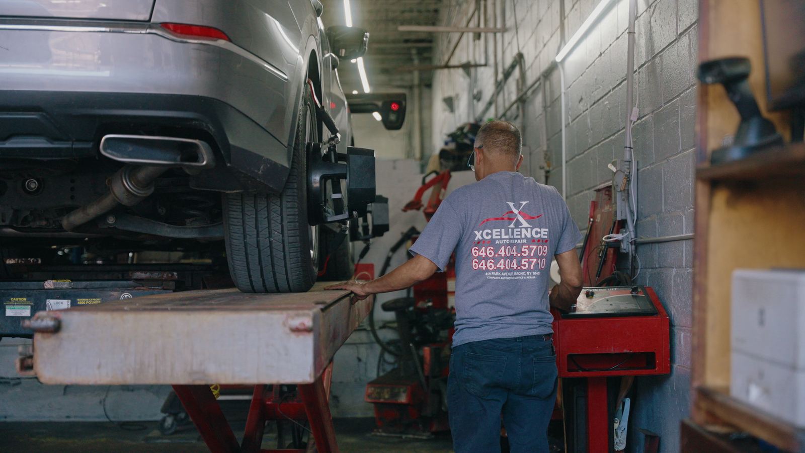 Excellence Auto Repair technician running a wheel alignment on a lifted SUV