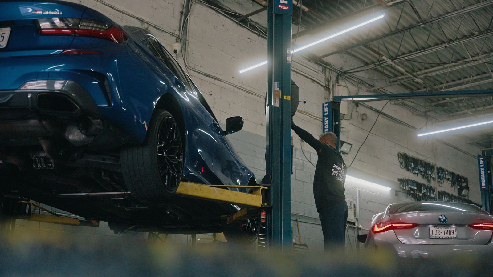 Technician raising a BMW on a two-post lift
