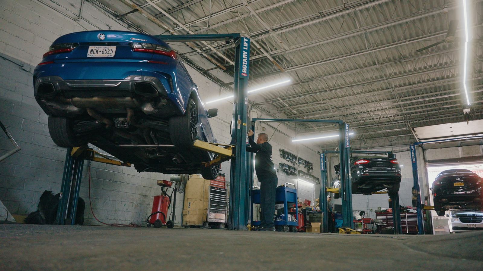 Cars on lifts inside Excellence Auto Repair
